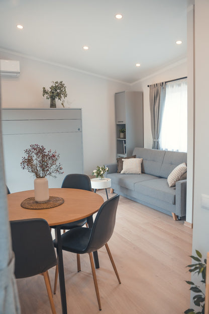 Skats uz dzīvojamo istabu mūsu mini moduļu mājā, kuru klients izīrē Airbnb un Booking platformās īstermiņā