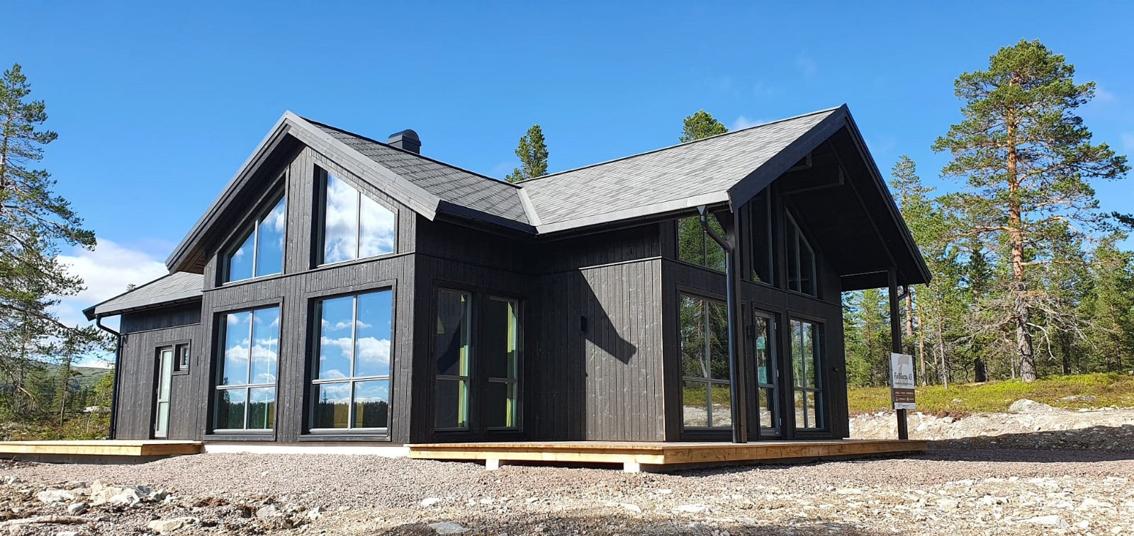 Moderna privātmāja ar lieliem logiem un dedzināta koka imitācijas ārējo fasādi